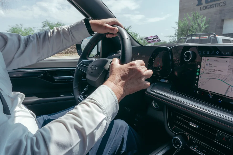 Real photo of someone's hands on a steering wheel